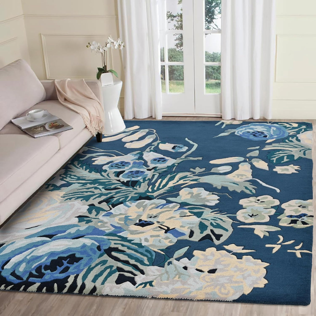 Modern living room with blue floral rug, sofa, French doors.