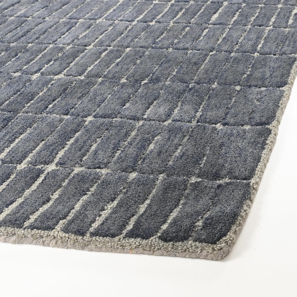 Close-up grey rug with raised rectangular pattern.