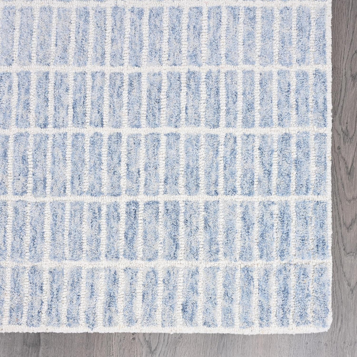 Close-up light blue-white striped wool rug.