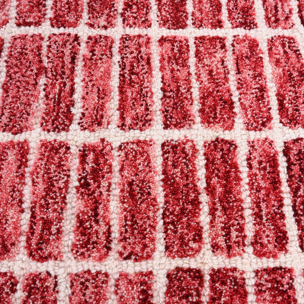 Close-up red-off-white shaggy patterned rug.