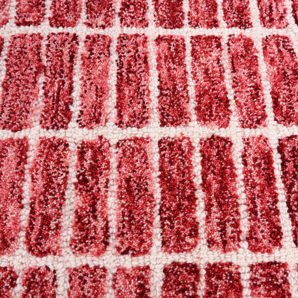 Close-up red-off-white shaggy patterned rug.