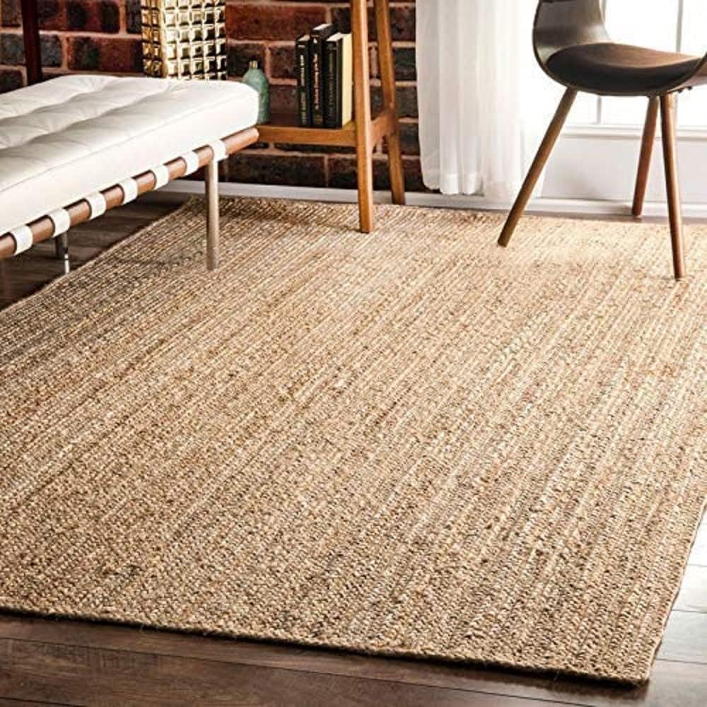 Close-up jute rug, wood floor, bench, chair.